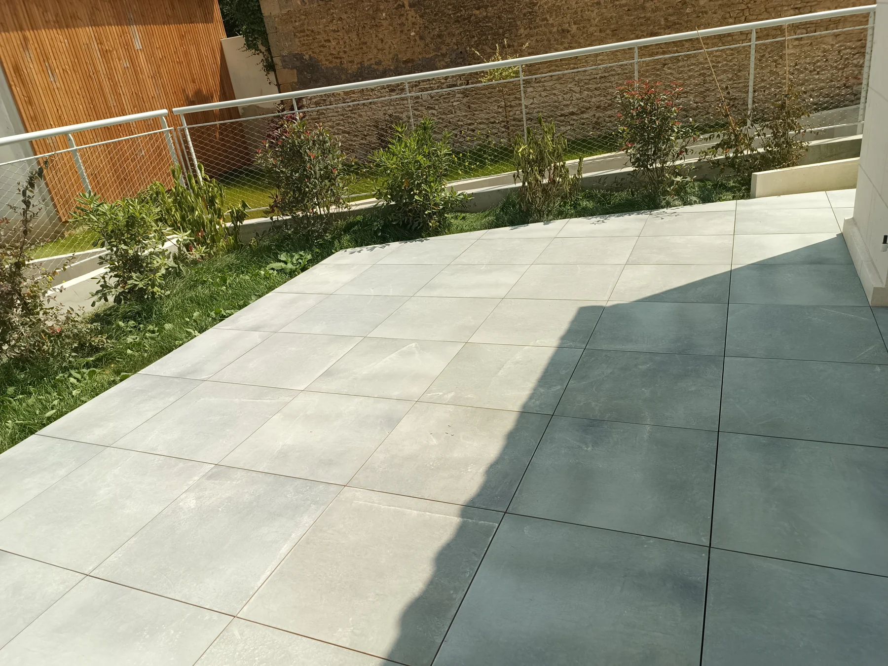 Terrasse en dalles grises ouverte sur le jardin