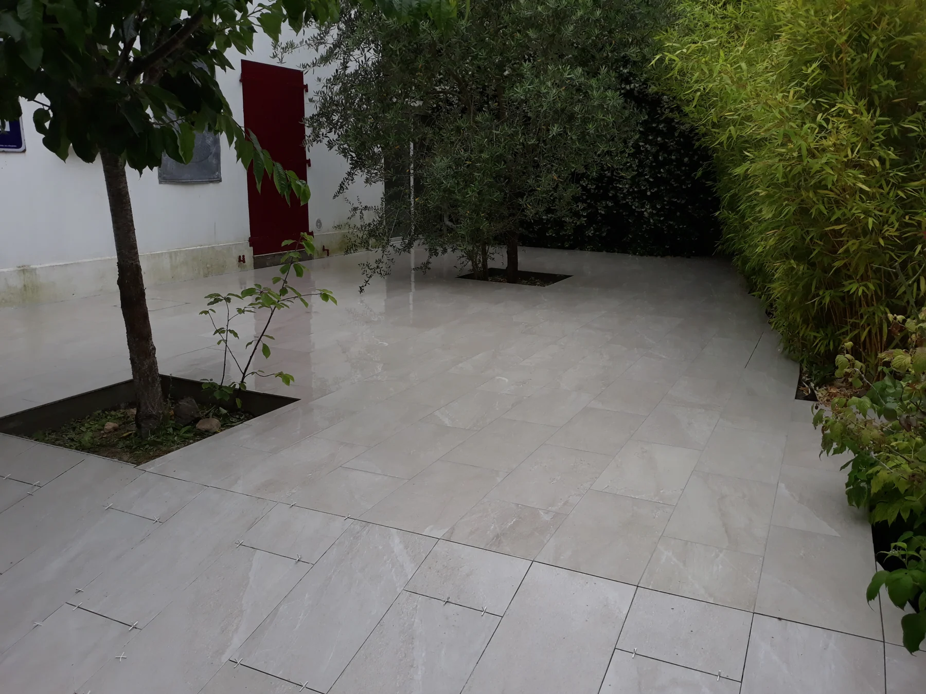 Terrasse carrelée autour des arbres du jardin