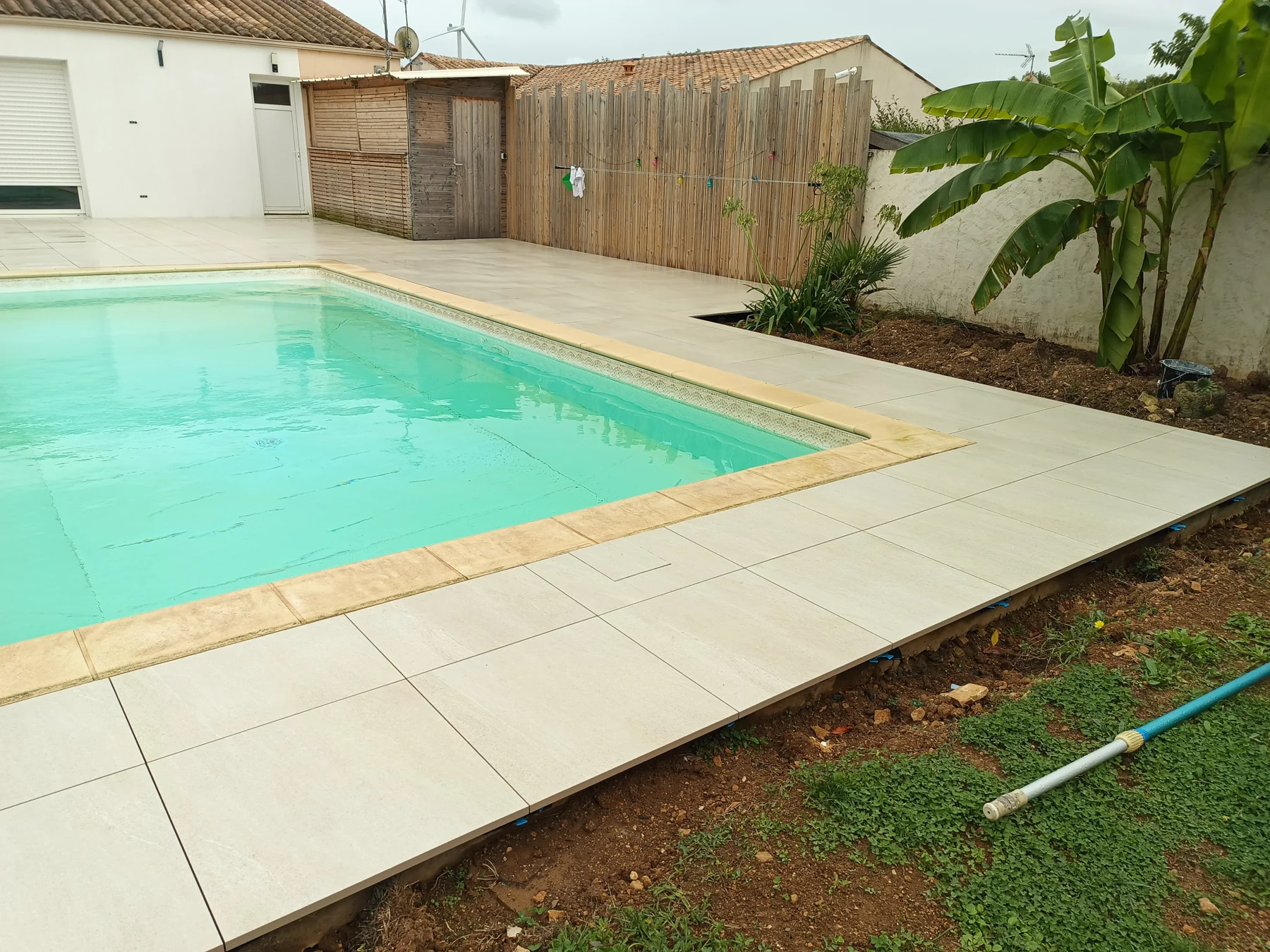 Terrasse en dalles claires autour d’une piscine